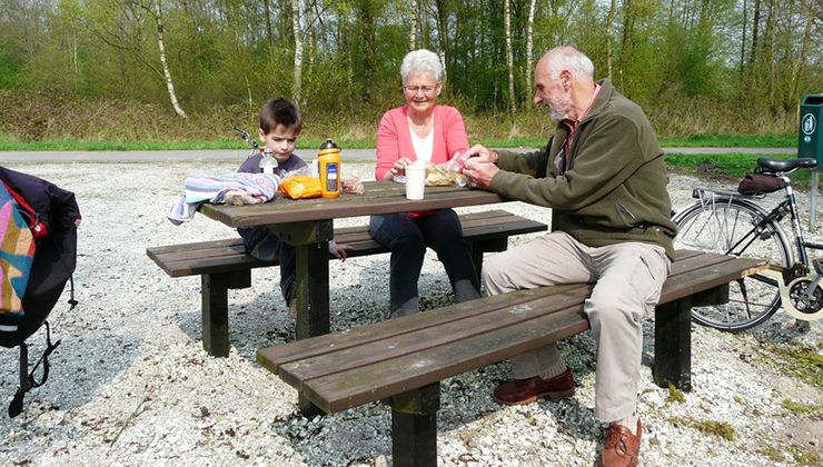 opa en oma met kleinkind lunchen in het bos