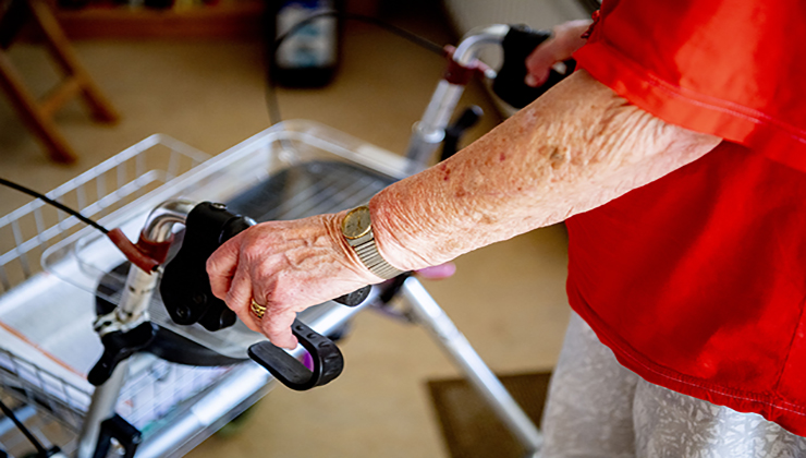 een oudere vrouw met rollator